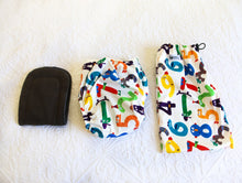 Load image into Gallery viewer, Nappy with design of brightly coloured number creatures on a soft white background.