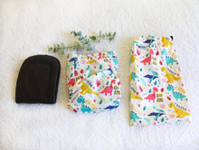 Load image into Gallery viewer, Baby dinosaurs in blue, aqua, coral and yellow - on a fresh white nappy, with charcoal grey interior.