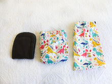 Load image into Gallery viewer, Baby dinosaurs in blue, aqua, coral and yellow - on a fresh white nappy, with charcoal grey interior.