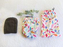 Load image into Gallery viewer, Warm pastel coloured feathers on silky white nappy, with charcoal grey inner.
