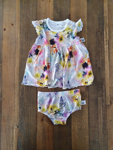 A romper in a stunning water colour style print with vibrant hints of lilac, yellow, orange and pink.