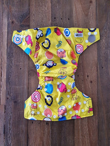 Bold designed nappy, in sunshine yellow with cartoon animal faces including a monkey, giraffe and elephant, amongst others. 