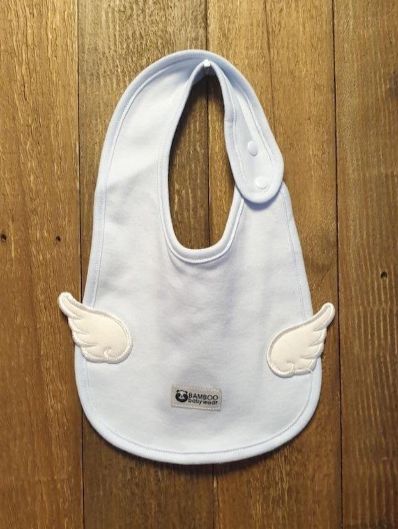 Baby blue bib, with pearly white wings on a wooden background. 