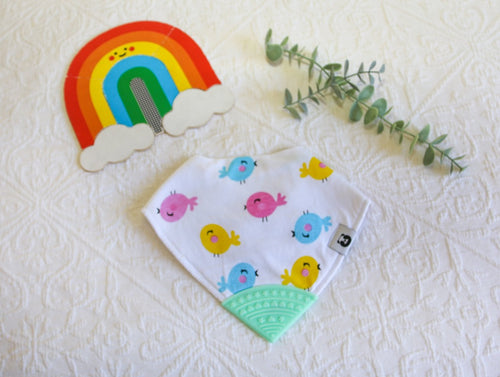 Neon pink, turquoise and pink round birdies on a white bib, with a mint green teething tip.