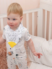 Load image into Gallery viewer, Baby stands in cot, with onesie and bib on.