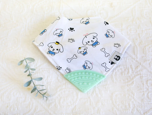 Little cartoon dogs in blue outfit on white bib with black paws & bones, with a green teething tip.