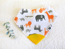 Load image into Gallery viewer, Jungle favourites lion, giraffe, zebra and elephant in greys and burnt orange tones on a white bib, with a yellow teething tip.