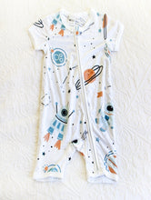 Load image into Gallery viewer, White onesie with blue planets and rockets, and beige and black accents depicting planets and stars/