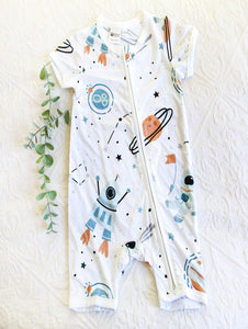 Cool onesie in neutral tones including blues, beige and black on a white background.