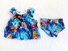 Load image into Gallery viewer, Bold and beautiful watercolour style romper, consisting of a dress and matching knickers. In shades of indigo, turquiose and midnight blue, with hot pink and sunny orange fireflies in jars.