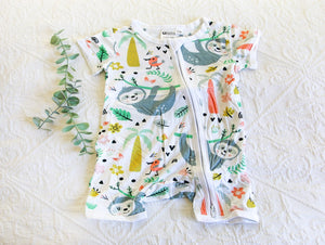 A calming and soft sloth with some brighter trees and tones, on a white short sleeved onesie. 