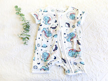 Load image into Gallery viewer, Baby blue T-rex&#39;s flying through space with stars and planets on a short white onesie.