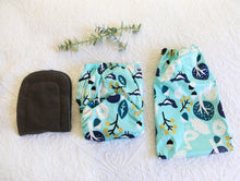 Load image into Gallery viewer, Alt Text: An aqua coloured nappy with navy blue and white birds, trees and acorns. 