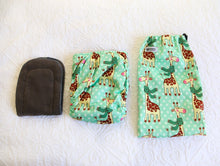 Load image into Gallery viewer, Mint green nappy with big smiley giraffes wearing dark green scarfs. 