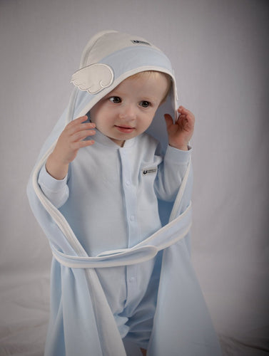 Small child models a baby blue towel with belt and pearly white wings. 