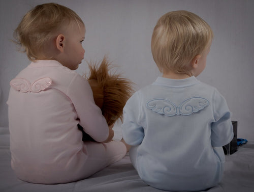 Babies sat on floor, with back of onesies on display. Image of both pink and blue angel wing onesies.